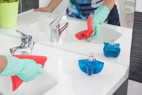 A local cleaner tidying a kitchen during a regular visit in Tooting